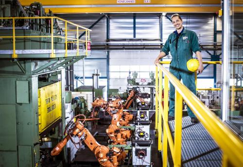 Medewerker VDL Weweler staat boven de volledig geautomatiseerde productielijn.